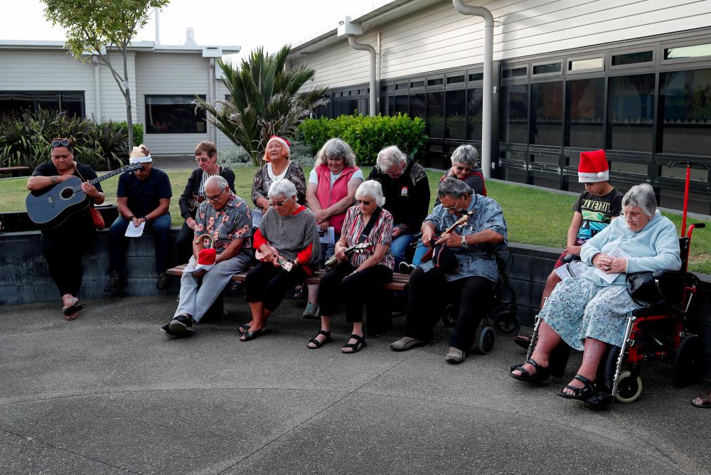 People observe a minute of silence as the pay their respects to the victims of the White Island volcano eruption, at the hospital in Whakatane, New Zealand, Dec 10. — AFP