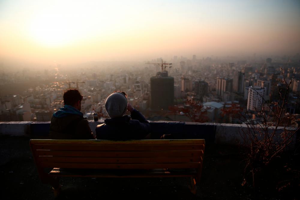 Iranian men look at the view in north of Tehran, Iran on Dec 12. — Reuters