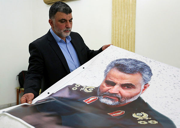 A man holds a banner depicting late Major-General Qassem Soleimani, head of the elite Quds Force, who was killed in a US airstrike near Baghdad, at the Iranian embassy in Beirut, Lebanon, on Jan 3. — Reuters