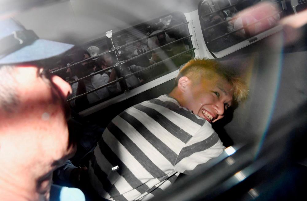 Satoshi Uematsu, suspected of a deadly attack at a facility for the disabled, is seen inside a police car as he is taken to prosecutors, at Tsukui police station in Sagamihara, Kanagawa prefecture, Japan, in this photo taken by Kyodo July 27, 2016. — Reuters