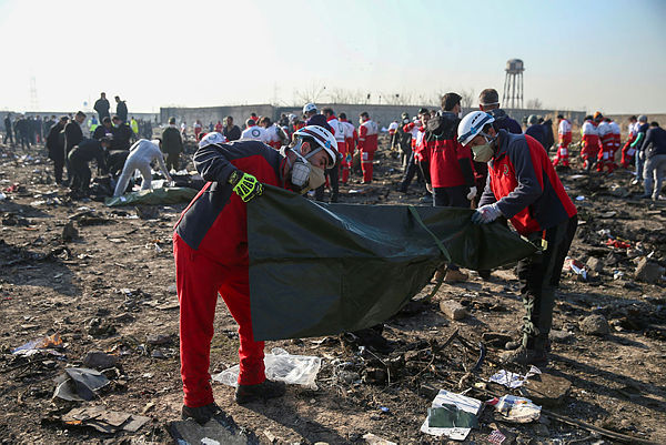 Red Crescent workers check plastic bags at the site where the Ukraine International Airlines plane crashed after take-off from Iran’s Imam Khomeini airport, on the outskirts of Tehran, Iran Jan 8 — Reuters