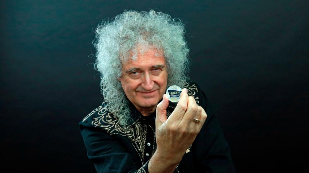 Guitarist Brian May of band Queen poses with a 5-pound coin in this undated picture obtained by Reuters on January 17, 2020. Courtesy of Queen Productions LTD/via REUTERS