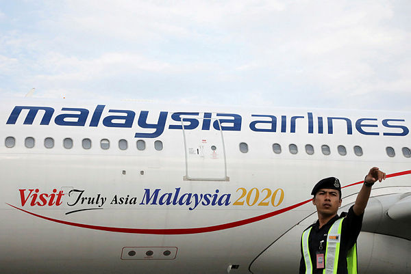 Airport staff works beside a Malaysia Airlines plane at Kuala Lumpur International Airport in Sepang. REUTERSPIX