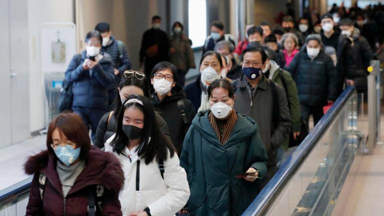 Passengers arriving from the Chinese city of Wuhan arrive at Narita Airport in Chiba, Japan in this photo taken by Kyodo on Jan 23. — Reuters