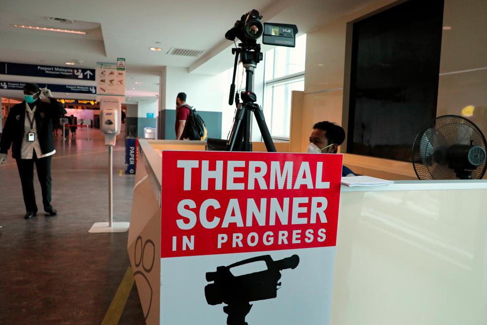 A Malaysian health quarantine officer waits for passengers at a thermal screening point at the international arrival terminal of Kuala Lumpur International Airport 2 in Sepang, Malaysia, Jan 27. — Reuters