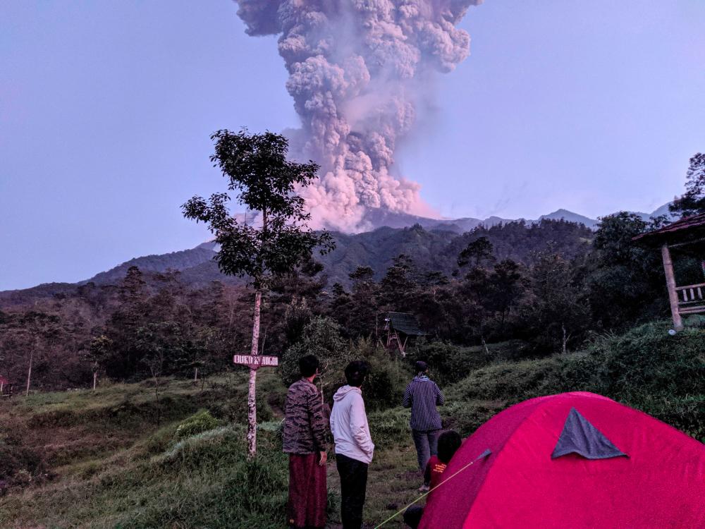 Tourists look towards Mount Merapi volcano as it erupts, at Cangkringan district in Sleman, Yogyakarta, Indonesia on Mar 3, in this photo taken by Antara Foto. — Reuters