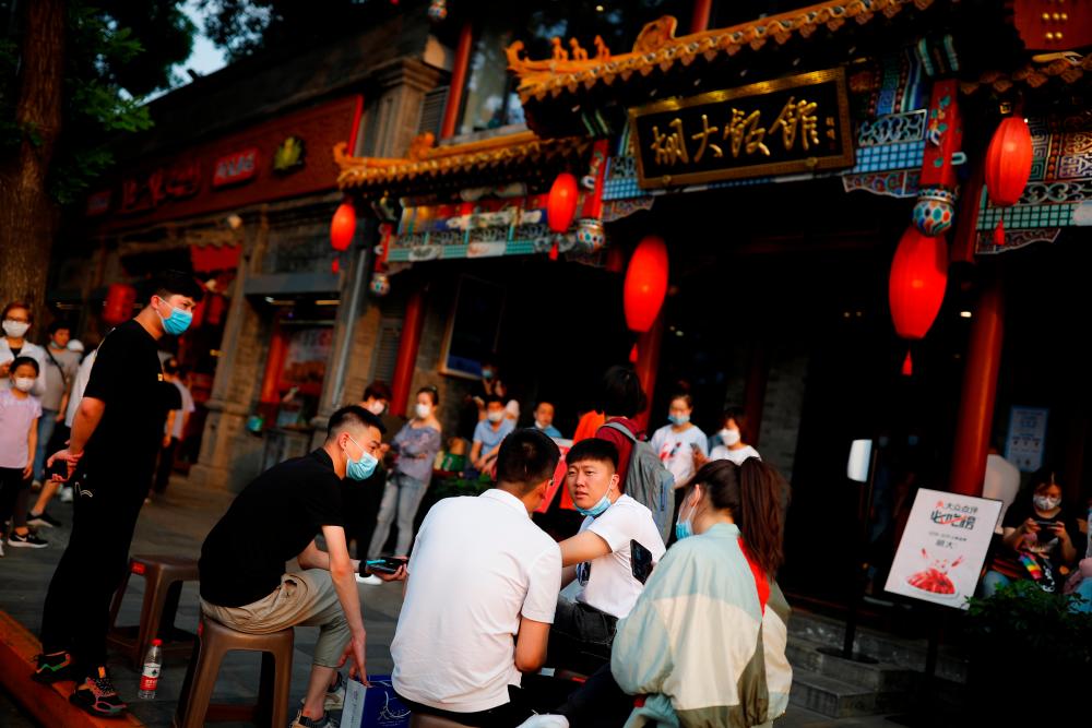 People wait to be seated outside a popular restaurant following the coronavirus disease (Covid-19) outbreak in Beijing, China, May 29, 2020. — Reuters
