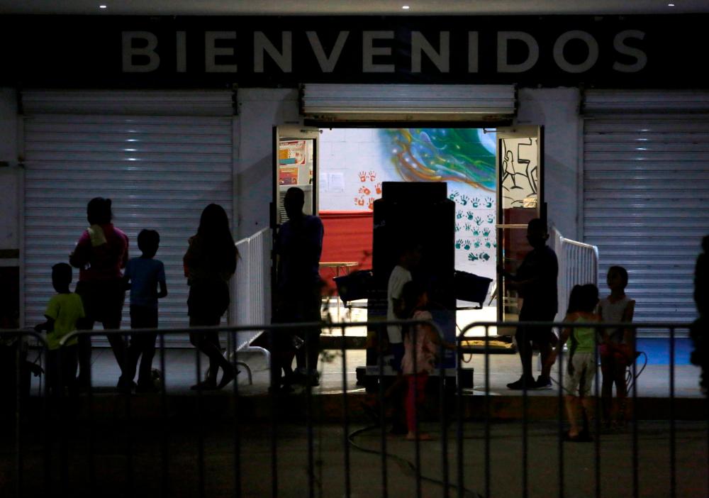 Migrants are seen in the entrance at the Leona Vicario center, after 12 migrants tested positive for coronavirus at a government-run shelter in the Mexican border city of Ciudad Juarez, as the outbreak of coronavirus disease (Covid-19) continues, in Ciudad Juarez, Mexico May 29, 2020. — Reuters