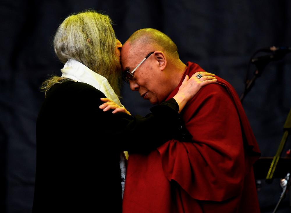 $!Patti Smith kisses the Dalai Lama as she performs on the Pyramid stage at Worthy Farm in Somerset during the Glastonbury Festival in Britain, June 28, 2015. REUTERS/Dylan Martinez/File Photo