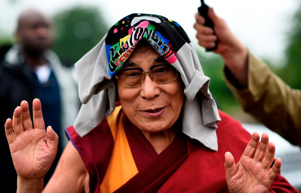 The Dalai Lama greets well-wishers before addressing a crowd gathered at the Stone Circles at Worthy Farm in Somerset during the Glastonbury Festival in Britain, June 28, 2015. REUTERS/Dylan Martinez/File Photo
