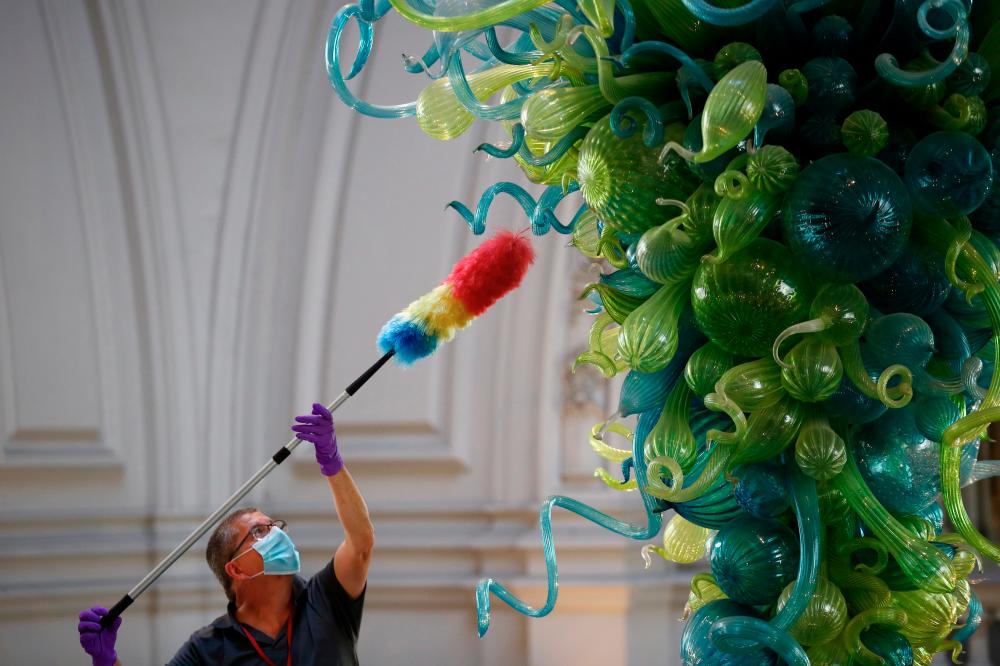 $!A museum technician cleans the V&amp;A Rotunda Chandelier by Dale Chihuly during preparations to reopen the Victoria &amp; Albert (V&amp;A) Museum, after the outbreak of the coronavirus disease (COVID-19) caused its closure, in London, Britain, August 4, 2020. Picture taken August 4, 2020. REUTERS/Hannah McKay
