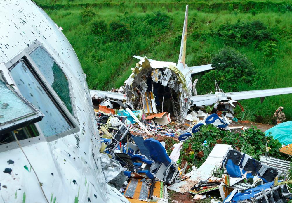 A security official inspects the site where a passenger plane crashed when it overshot the runway at the Calicut International Airport in Karipur, in the southern state of Kerala, India, August 8, 2020. — Reuters