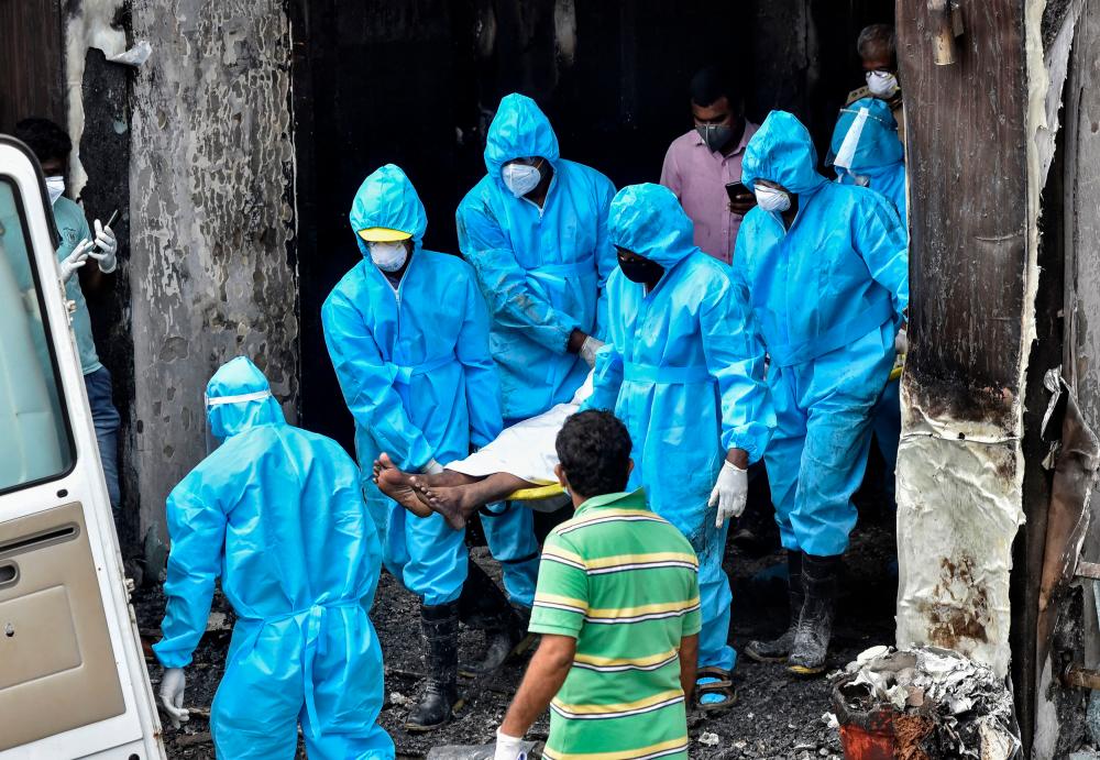 Rescue workers carry the body of a patient suffering from coronavirus disease (Covid-19), who died after a fire broke out in a hotel that was being used as a Covid-19 facility, in Vijayawada, in the southern state of Andhra Pradesh, India, August 9, 2020. — Reuters