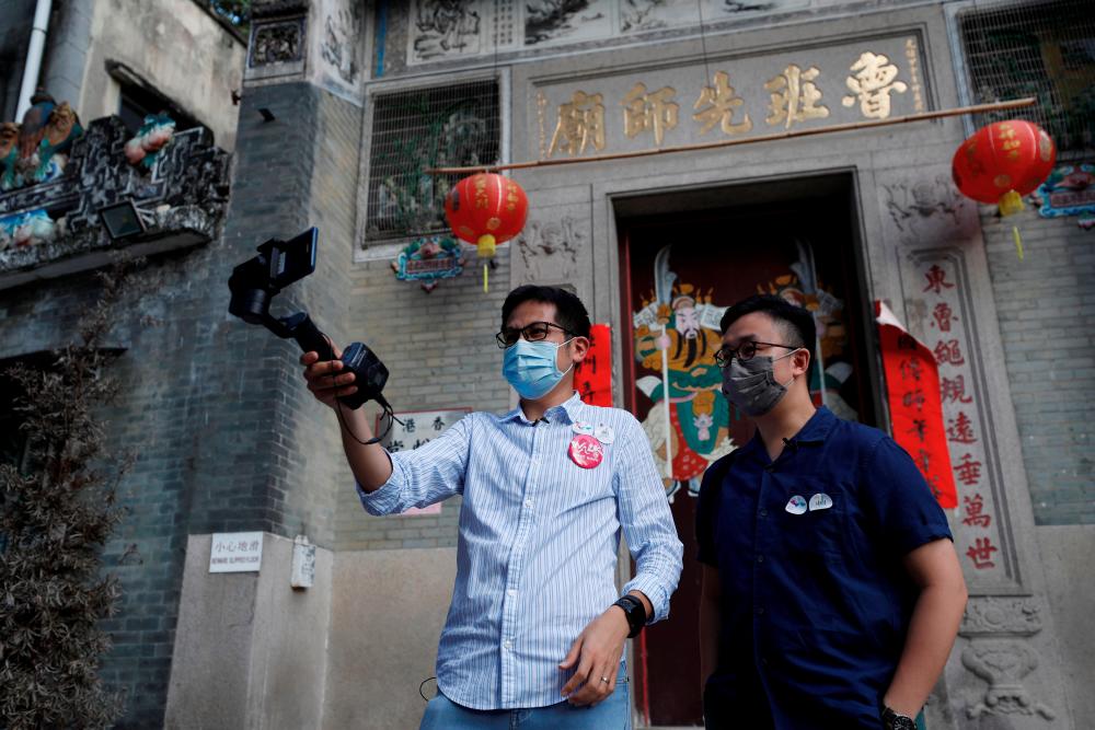 Paul Chan, tour guide and CEO of Walk in Hong Kong, and Charles Lai, architect, speak during a live streamed virtual tour, following the coronavirus disease (COVID-19) outbreak in Hong Kong, China August 16, 2020. Picture taken August 16, 2020. REUTERS/Tyrone Siu