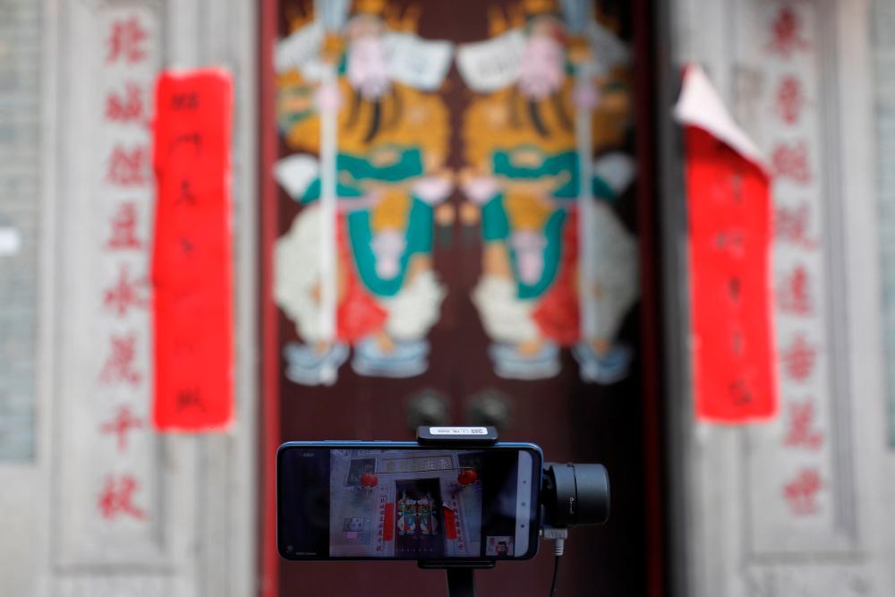 $!A smart phone films a door of Lo Pan Temple, during a virtual tour, following the coronavirus disease (COVID-19) outbreak in Hong Kong, China August 16, 2020. Picture taken August 16, 2020. REUTERS/Tyrone Siu