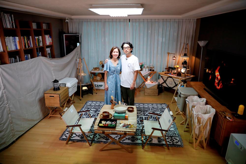 Lee Seung-yoon and his wife Che Min-hee pose for photographs after setting up camping gear during a staycation at their home amid the coronavirus disease (COVID-19) pandemic, in Seoul, South Korea, August 22, 2020. Picture taken on August 22, 2020. REUTERS/Kim Hong-Ji