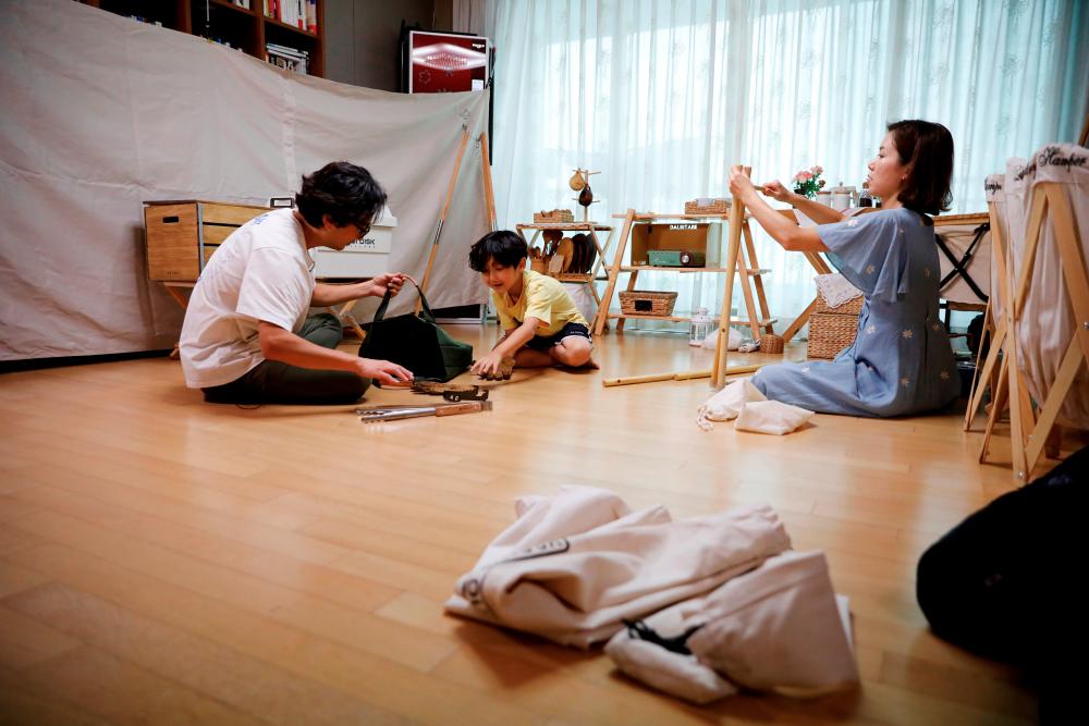 $!Lee Seung-yoon, his wife Che Min-hee and their son Lee Ji-sung set up camping gear as they prepare for a staycation at their home amid the coronavirus disease (COVID-19) pandemic, in Seoul, South Korea, August 22, 2020. Picture taken on August 22, 2020. REUTERS/Kim Hong-Ji
