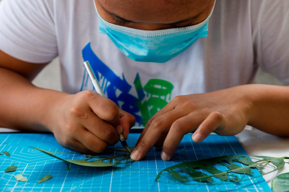 $!Filipino artist Mary Mae Dacanay, who lost her job due to the coronavirus disease (COVID-19) outbreak, makes portraits and illustrations out of leaves as a new source of income, in her home in Binan, Laguna, Philippines, September 1, 2020. Picture taken September 1, 2020. REUTERS/Eloisa Lopez