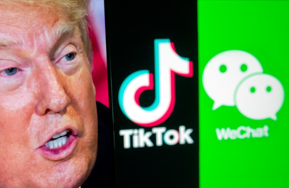 A picture of U.S President Donald Trump is seen on a smartphone in front of displayed Tik Tok and WeChat logos in this illustration taken Sept 18, 2020. — AFP