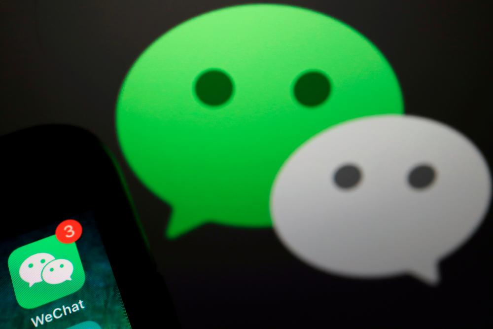 FILE PHOTO: The messenger app WeChat is seen next to its logo in this illustration picture taken August 7, 2020. REUTERS/Florence Lo/Illustration/File Photo