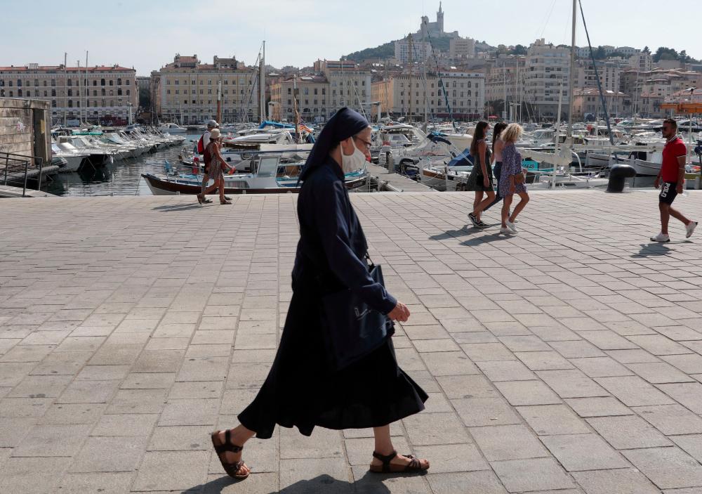 A nun wearing a protective face mask walks at the Old Port (Vieux Port) in Marseille, France, Sept 17, 2020. — AFP