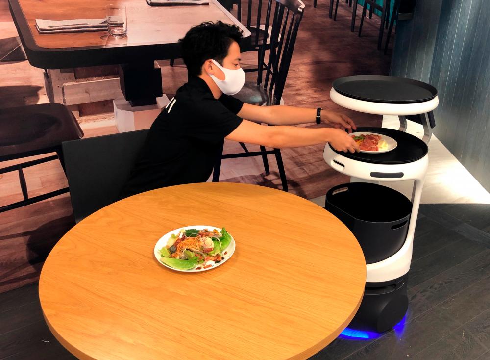 $!SoftBank’s robotics arm demonstrates a food service robot Servi, developed by California-based Bear Robotics to Japan as restaurants grapple with labour shortages and seek to ensure social distancing during the coronavirus disease (COVID-19) outbreak, in Tokyo, Japan, September 28, 2020. REUTERS/Akira Tomoshige