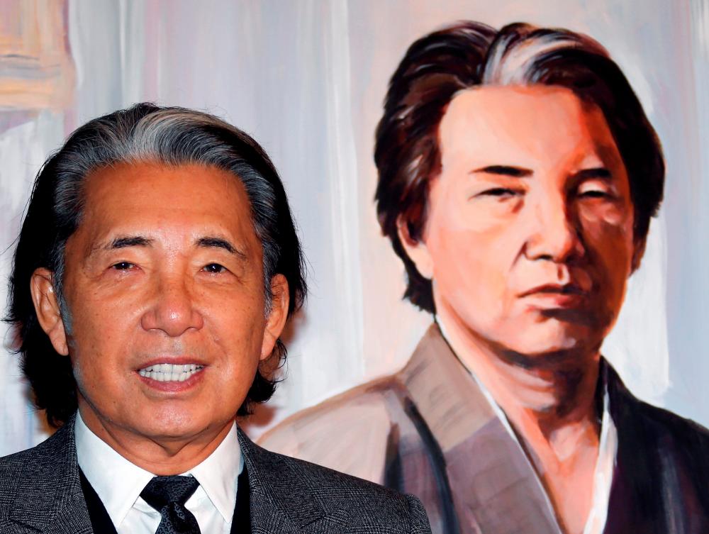 $!Japanese fashion designer Kenzo Takada poses next to a painting of his self-portrait offered to Monaco’s Princess Stephanie’s “Fight Aids” foundation gala auction on World AIDS Day in Monaco December 1, 2014. REUTERS/Eric Gaillard/File Photo