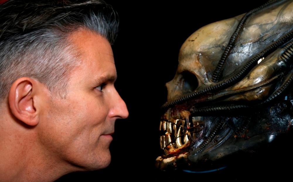 Stephen Lane, CEO of Prop Store, poses for a photograph with a special effects mechanical head from the film Alien at a preview of a movie and TV memorabilia auction in Rickmansworth, Britain October 15, 2020. Picture taken October 15, 2020. REUTERS/John Sibley