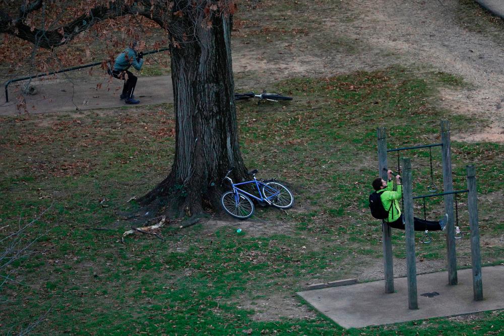 $!People perform exercises at a fitness area along the Rock Creek Park Trail amid the coronavirus disease (COVID-19) outbreak, in Washington, U.S., November 24, 2020. REUTERS/Tom Brenner