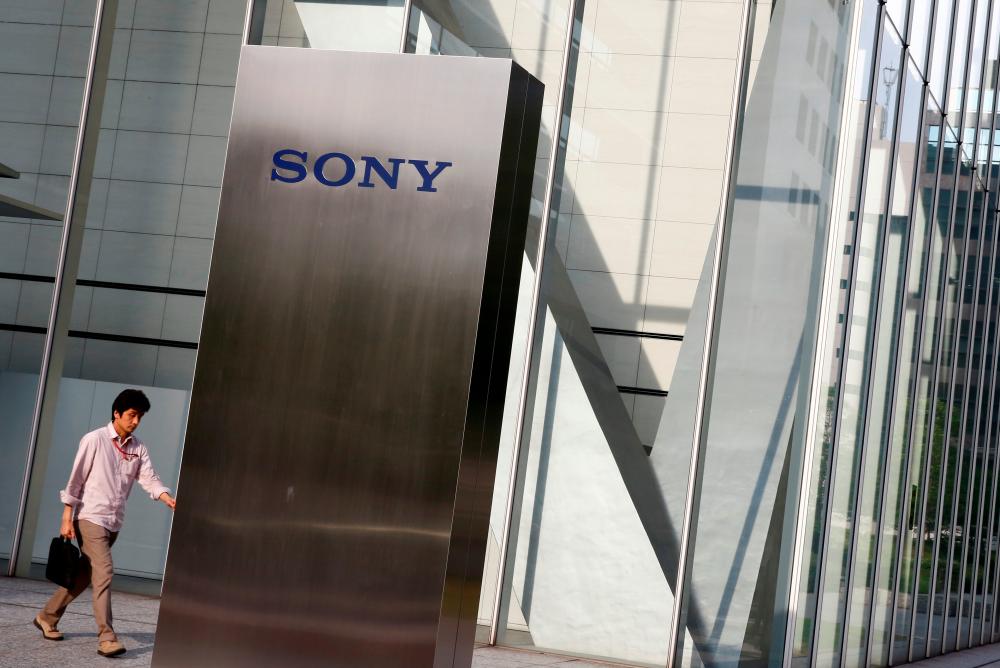 FILE PHOTO: A man walks past the Sony brand logo outside the headquarters of Sony Corp in Tokyo, Japan, May 24, 2016. REUTERS/Thomas Peter/File Photo
