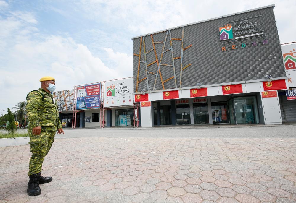 $!A People’s Volunteer Corp guard patrols a deserted area in Pekan Napoh in the Kubang Pasu district in Kedah. – MASRY CHE ANI/THESUN