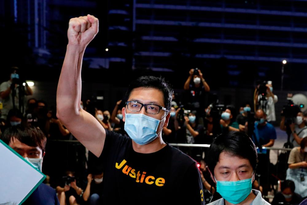 FILE PHOTO: Democratic Party lawmaker Lam Cheuk-ting raises a fist after being released on bail over anti-government protests in July last year at West Kowloon Magistrates’ Courts, in Hong Kong, China August 27, 2020. REUTERS/Tyrone Siu/File Photo