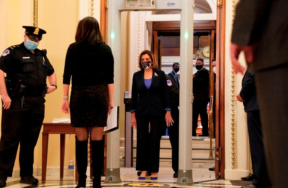 U.S. House Speaker Nancy Pelosi (D-CA) walks through a new metal detector outside the House chamber as the House prepares to vote on a resolution demanding Vice President Pence and the cabinet remove President Trump from office, at the U.S. Capitol in Washington, U.S., January 12, 2021. REUTERS/Erin Scott