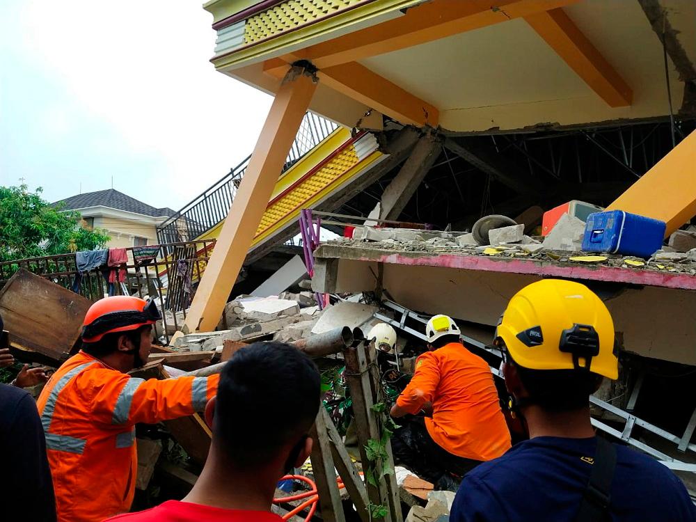 Members of a search and rescue agency team dig through rubble after an earthquake, in Mamuju, West Sulawesi province on January 15, 2021. — Reuters