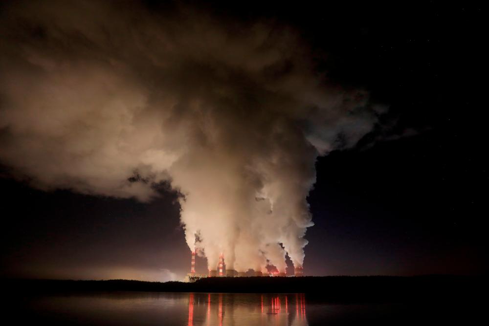 FILE PHOTO: Smoke and steam billow from Belchatow Power Station, Europe’s largest coal-fired power plant, operated by PGE Group, at night near Belchatow, Poland December 5, 2018. Picture taken December 5, 2018. REUTERS/Kacper Pempel/File Photo