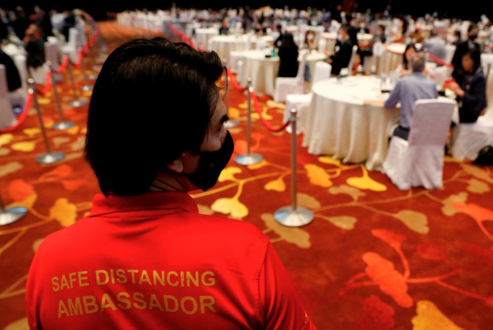 A social distancing ambassador watches on during a conference held by the Institute of Policy Studies at Marina Bay Sands Convention Centre in Singapore January 25, 2021. Picture taken January 25, 2021. REUTERS/Edgar Su