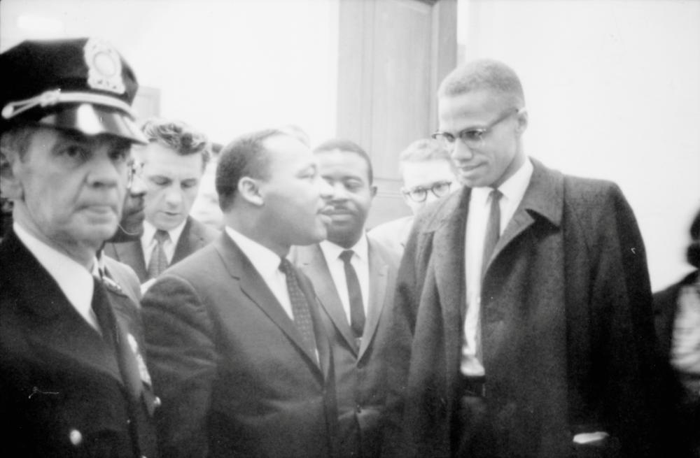 FILE PHOTO: Martin Luther King Jr. and Malcolm X wait for a press conference to begin in an unknown location, March 26, 1964. -Library of Congress/Marion S. Trikosko/Handout via Reuters
