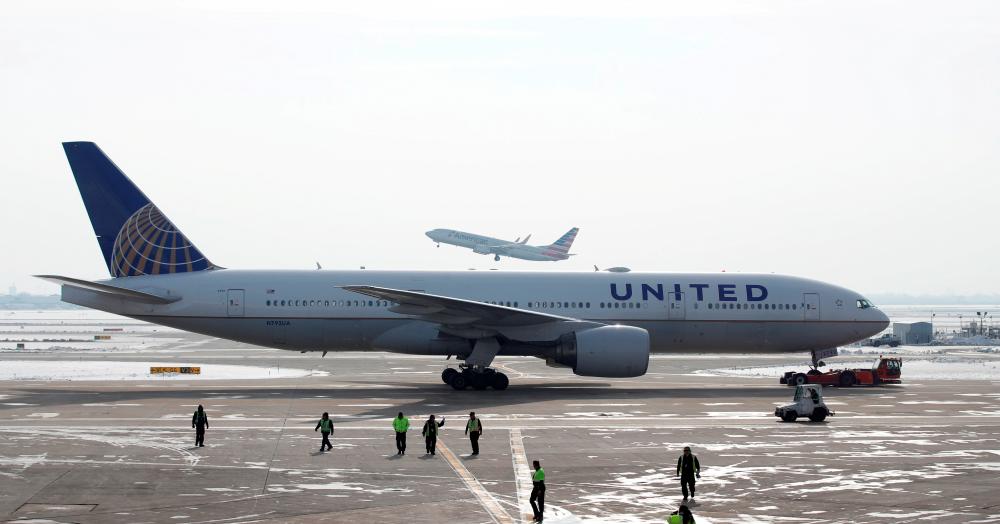 FILE PHOTO: A United Airlines Boeing 777-200ER plane is towed as an American Airlines Boeing 737 plane departs from O’Hare International Airport in Chicago, Illinois, U.S. Nov. 30, 2018. -Reuters