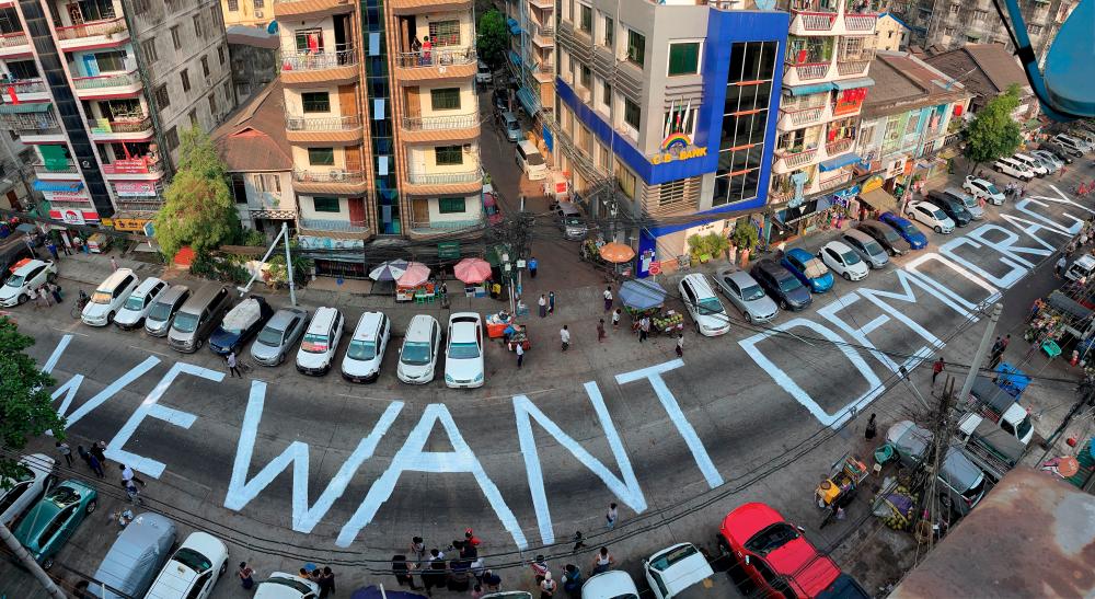 A slogan is written on a street as a protest after the coup in Yangon, Myanmar February 21, 2021. - Reuters