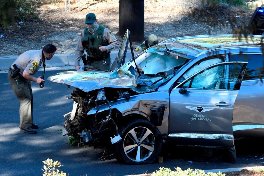 Los Angeles County Sheriff’s Deputies inspect the vehicle of golfer Tiger Woods, who was rushed to hospital after suffering multiple injuries, after it was involved in a single-vehicle accident in Los Angeles, California, U.S. February 23, 2021. - Reuters