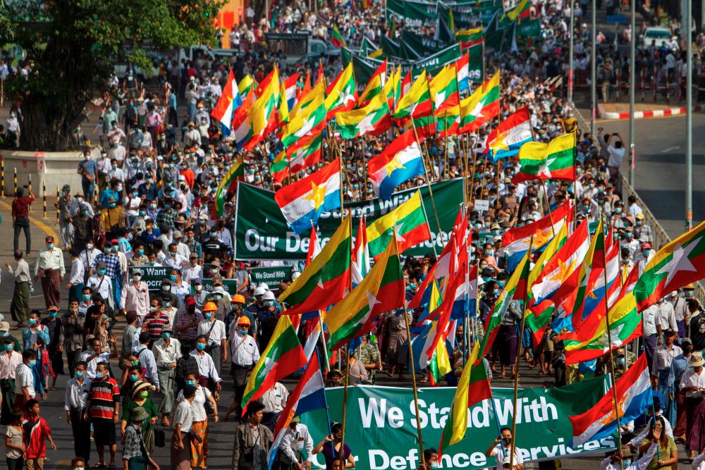 Supporters of Myanmar’s military carry banners and flags during a rally in Yangon, Myanmar February 25, 2021. - Reuters