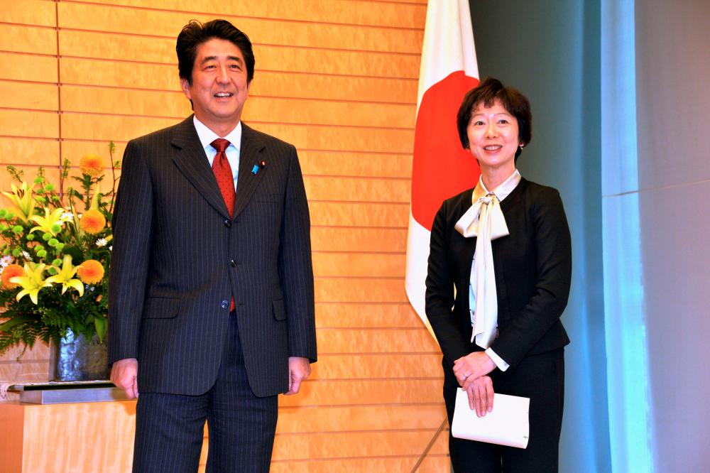 FILE PHOTO: Makiko Yamada and Japan Prime Minister Yoshihide Suga’s predecesstor, Shinzo Abe, smile as Abe appoints her as secretary to the prime minister in Tokyo November 29, 2013. - Reuters