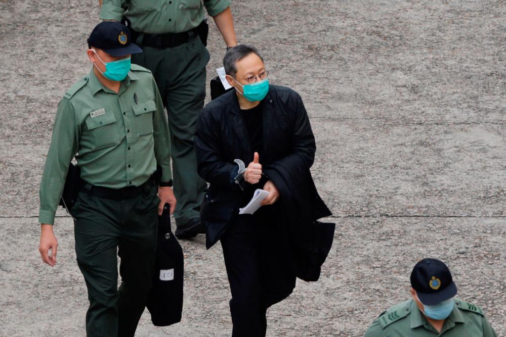 Pro-democracy activist Benny Tai flashes thumbs up as he walks to a prison van to head to court, over the national security law charge, in the early morning, in Hong Kong, China March 2, 2021. - Reuters