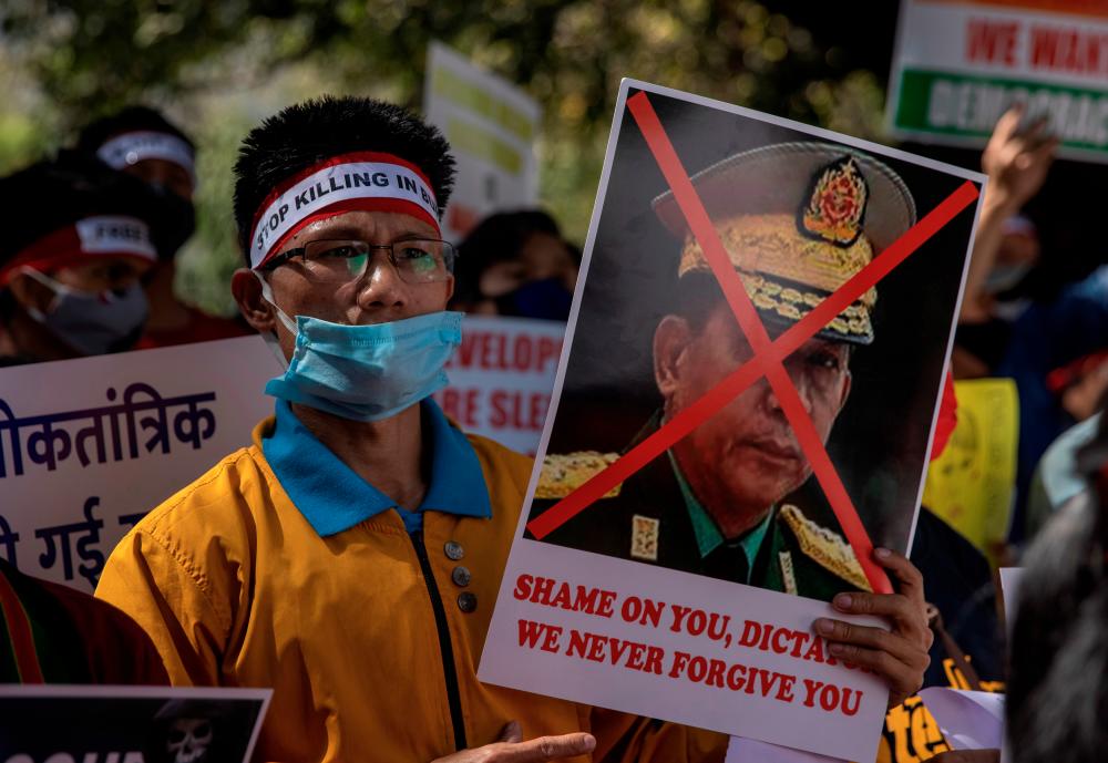 A Myanmar citizen living in India holds a poster of Myanmar’s army chief Senior General Min Aung Hlaing with his face crossed out during a protest, organised by Chin Refugee Committee, against the military coup in Myanmar, in New Delhi, India, March 3, 2021.- Reuters