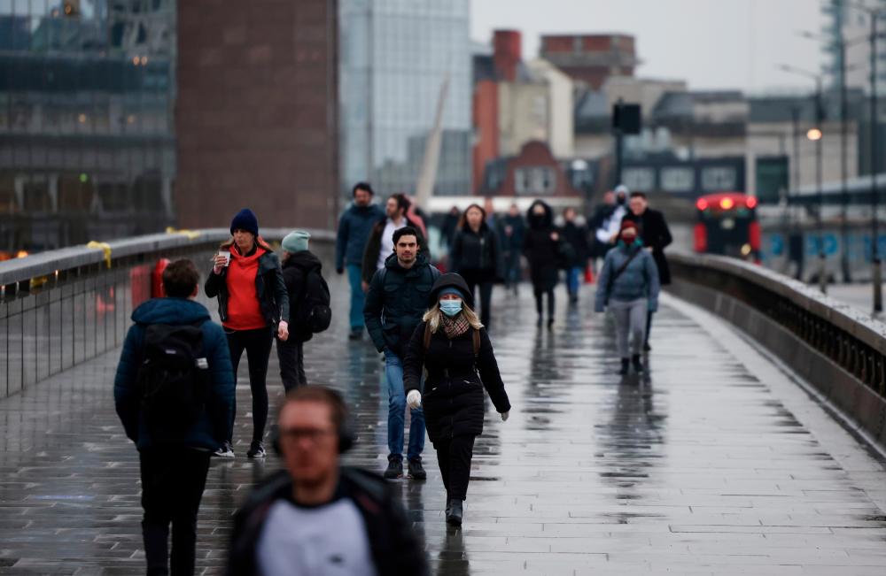 People walk over London Bridge during rush hour, amid the coronavirus disease (COVID-19) outbreak, in London, Britain, March 4, 2021. - Reuters