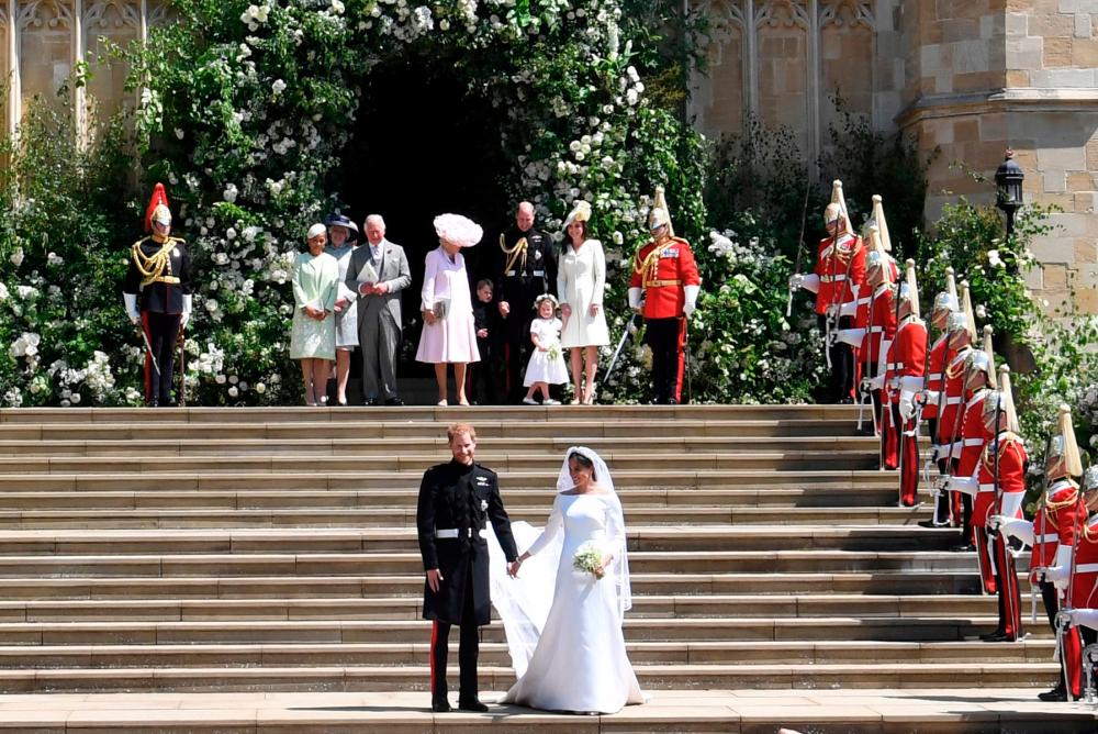 FILE PHOTO: Britain’s Prince Harry (L), Duke of Sussex and Meghan (R), Duchess of Sussex exit St George’s Chapel in Windsor Castle after their royal wedding ceremony, in Windsor, Britain, 19 May 2018. - Reuters