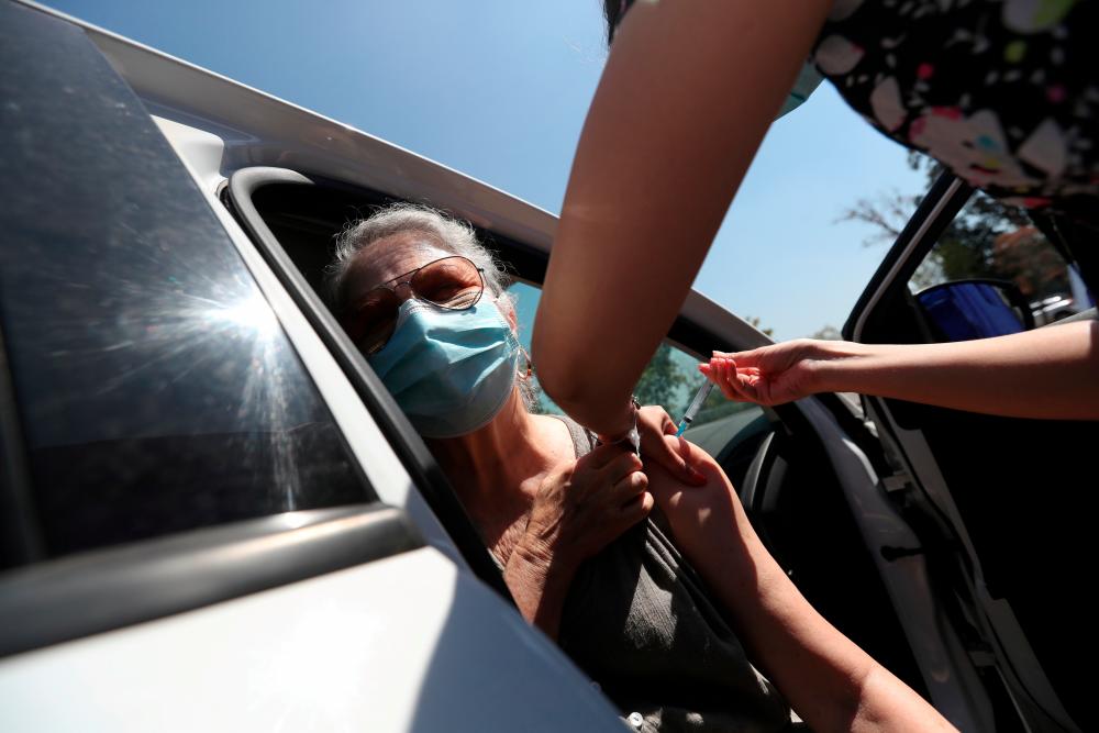 FILE PHOTO: A healthcare worker administers a dose of Sinovac’s CoronaVac coronavirus disease (COVID-19) vaccine at a drive-thru vaccination center in Santiago, Chile, February 26, 2021. - Reuters