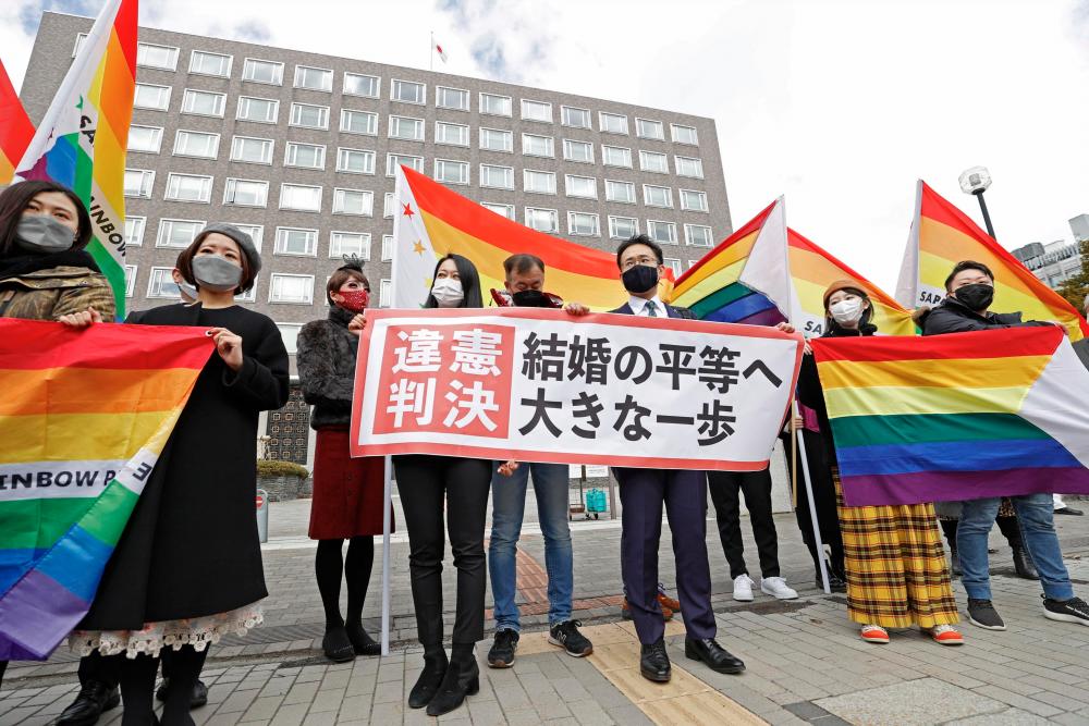 Plaintiffs’ lawyers and supporters show a banner that reads ‘Unconstitutional decision’ after a district court ruled on the legality of same-sex marriages outside Sapporo district court in Sapporo, Hokkaido, northern Japan March 17, 2021, in this photo taken by Kyodo.- Kyodo/via Reuters