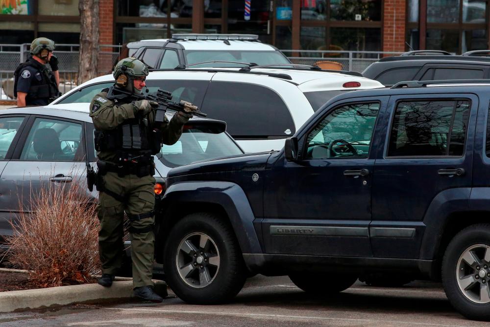 Law enforcement officers sweep the parking lot at the site of a shooting at a King Soopers grocery store in Boulder, Colorado, US March 22, 2021. - Reuters