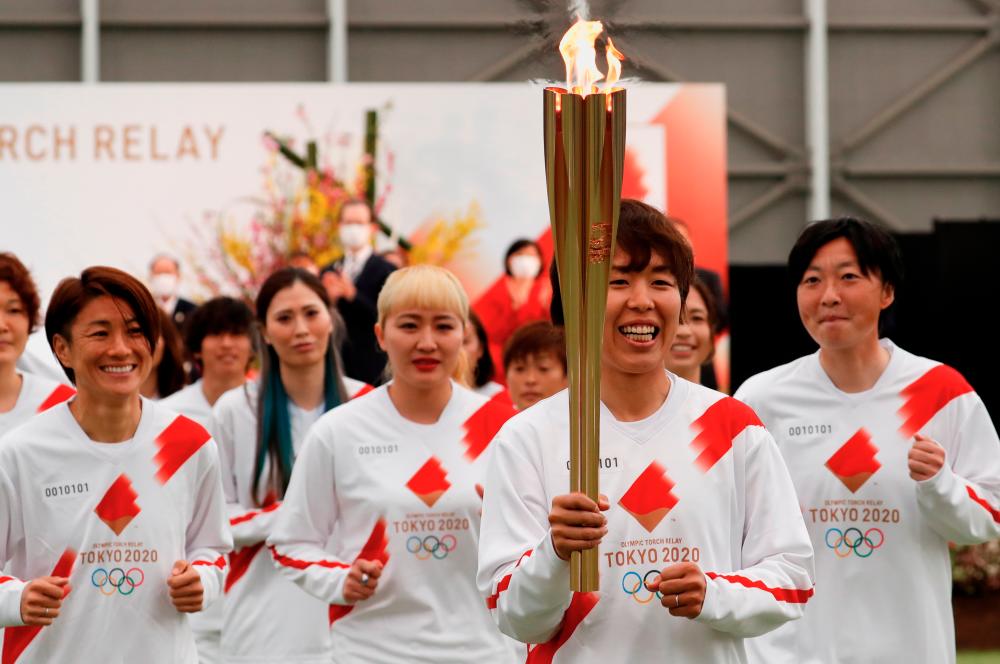 Tokyo 2020 Olympic Torch Relay Grand Start torchbearer Nadeshiko Japan, Japan’s women’s national soccer team, leads the torch relay in Naraha, Fukushima prefecture, Japan March 25, 2021. -Reuters